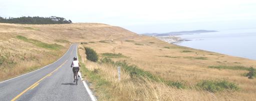 Bicycling on Cattle Point Road, San Juan Island. Washington state.