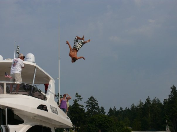 Fun in the summera a man flips off a luxury yacht into the water at Roche Harbor, San Juan Island.